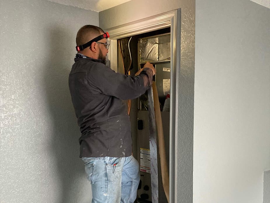 HVAC tech installing indoor furnace in residential closet